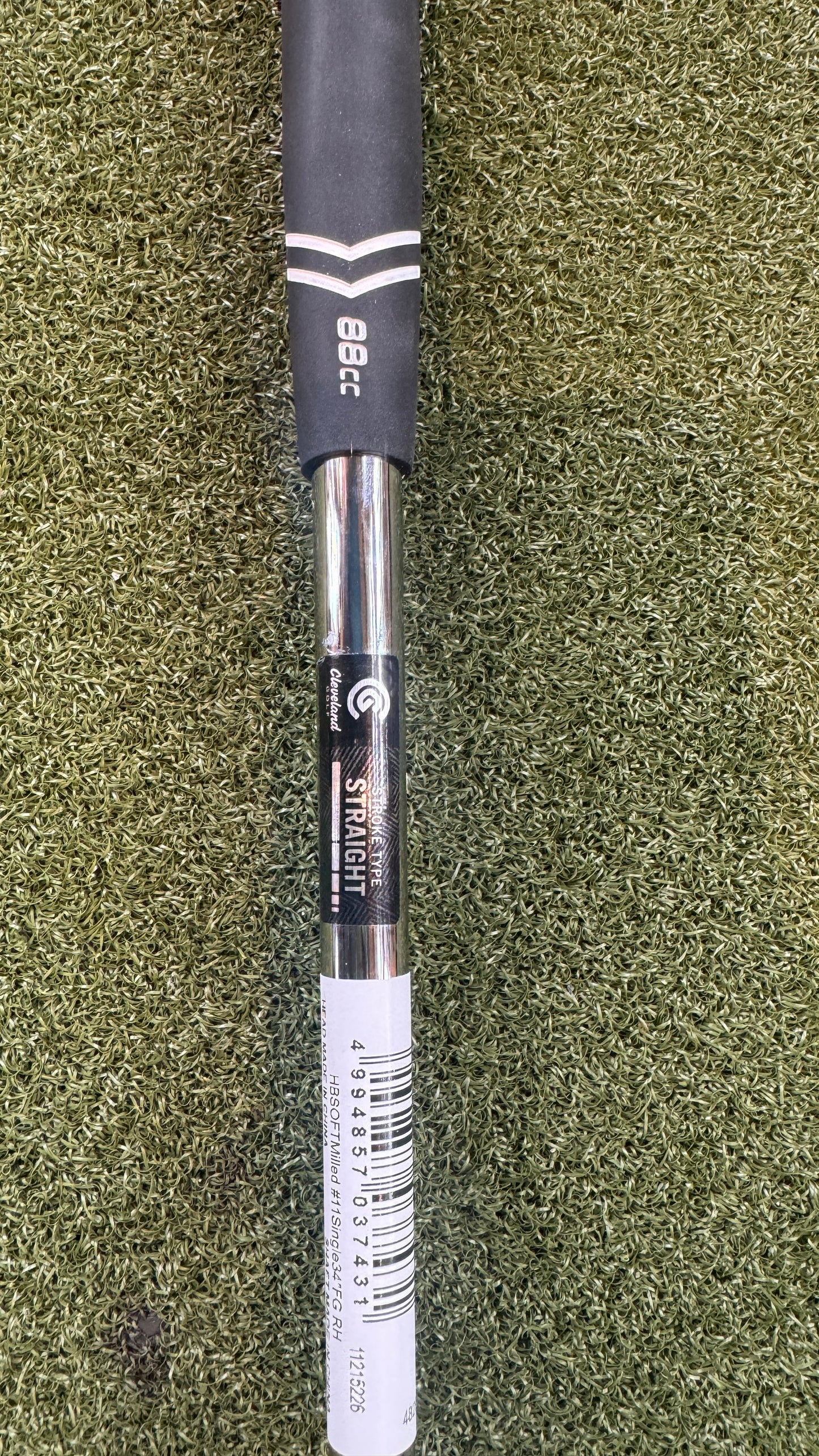 Golf club shaft with branding on a green grass background