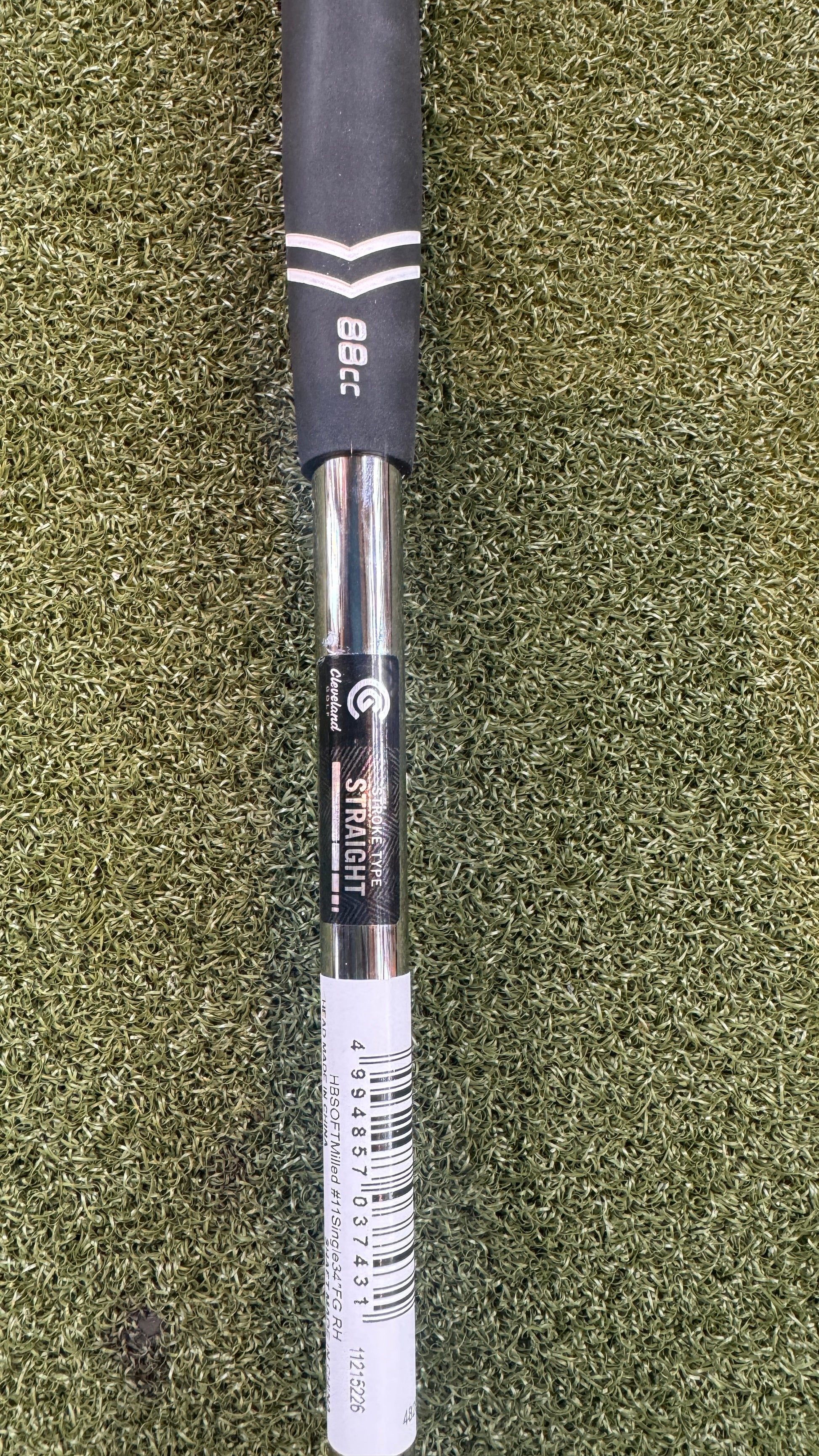 Golf club shaft with branding on a green grass background