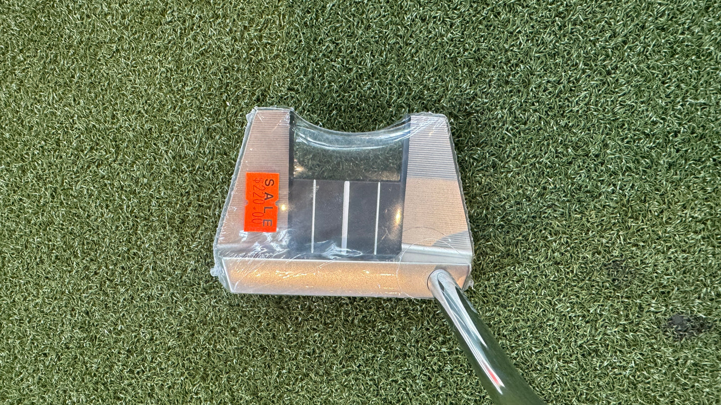 Golf putter with clear cover on a green grass background